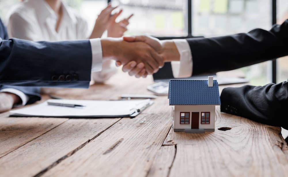 Immobilienmakler und Kunde am Tisch